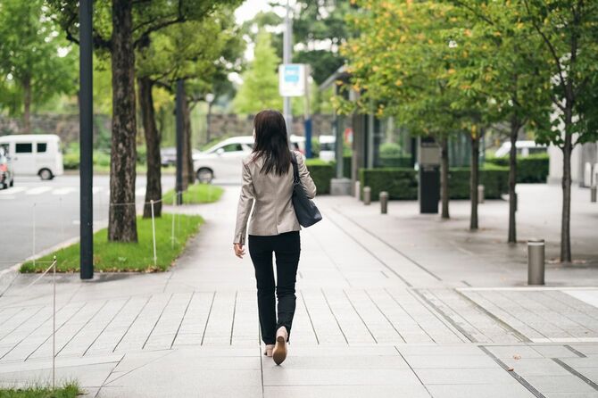 ダウンタウンを歩くビジネスウーマンの背面図