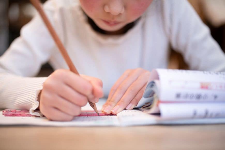 家で勉強している子供の手