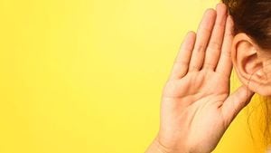 耳に手を当てて聞く人