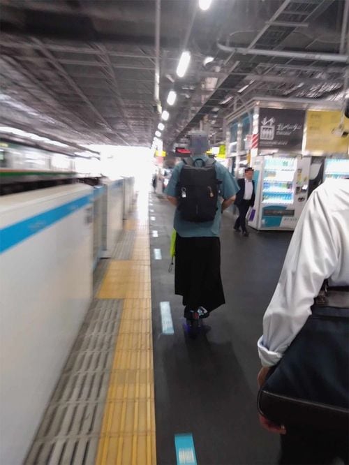 【写真1】JRのホームを電動キックボードで走る男性