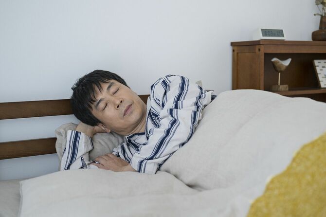 ベッドで眠る中年男性