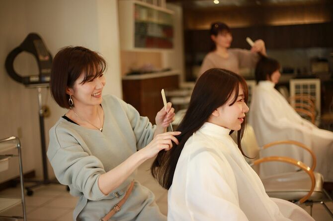 客と話しながら髪を切る美容師