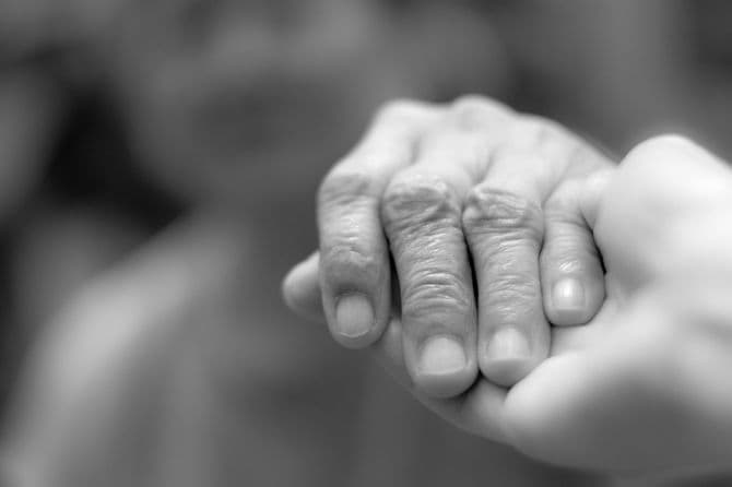 シニアの手を取る医療従事者の手