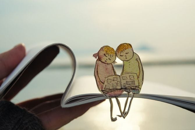 アルバムを眺める男女の人形