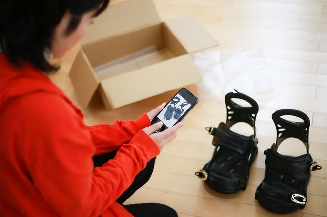 スノーボードパーツを撮影する女性