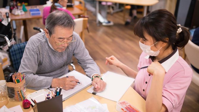 女性看護師の絵を描く高齢男性