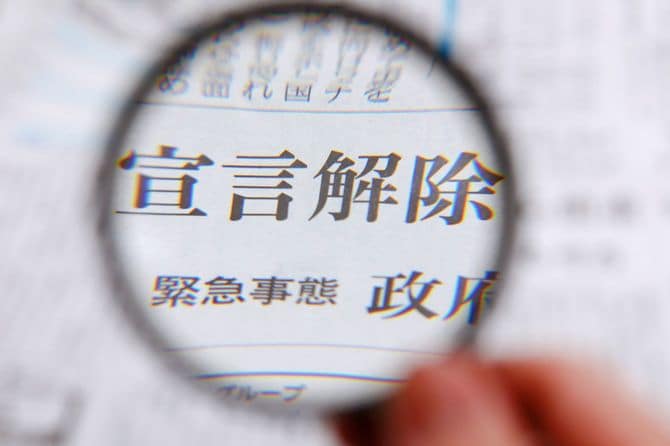 ルーペで拡大した新聞の見出しには、宣言解除の文字