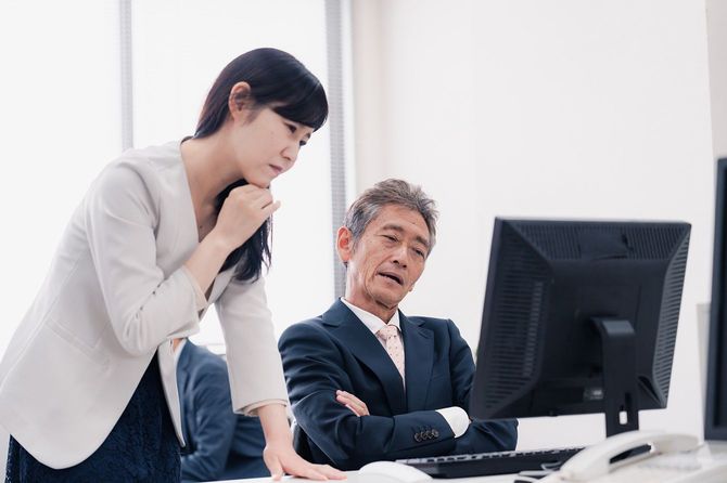 パソコンの画面を見て考える人たちのイメージ