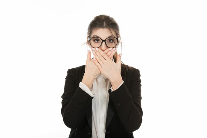 口を手で覆い、カメラを見つめている女性