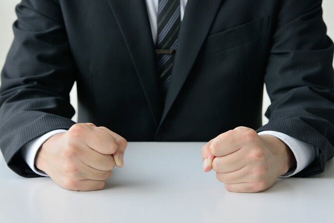 こぶしを握る男性