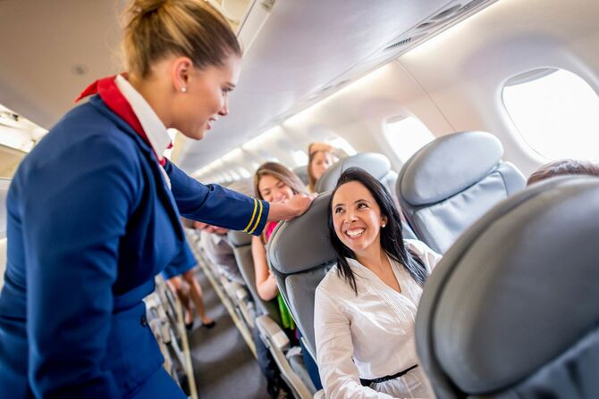 飛行機の機内で乗客に対応する客室乗務員