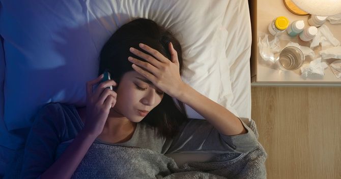 熱があり、横になる女性