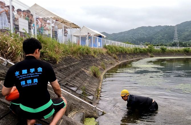 地域の子どもたちに、ため池の危険性を実演している様子(2023年5月撮影)