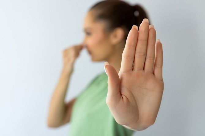 鼻をつまんでいる女性