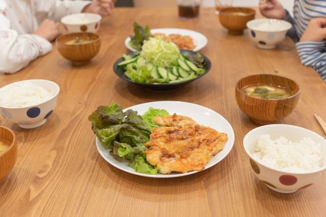 食卓で食事をする4人家族