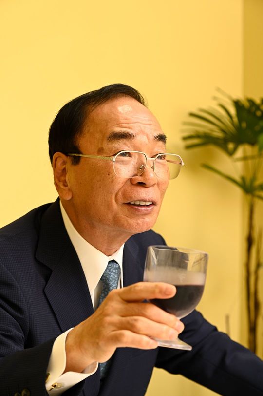 100円のグラスワインを手にする正垣会長