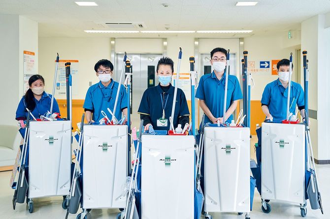 2020年からスタートした、鳥取県で障がい者雇用を積極的に行なっていた『さんびる』と障がい者就業生活支援センター『しゅーと』と『鳥取大学医学部附属病院』という3者での新しい取り組み。写真中央の清掃員・坂川ルミ子は、この枠組みで重要なポジションを担っているスタッフだ。