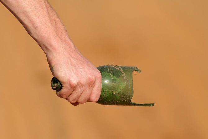 割れた瓶を持っている手元