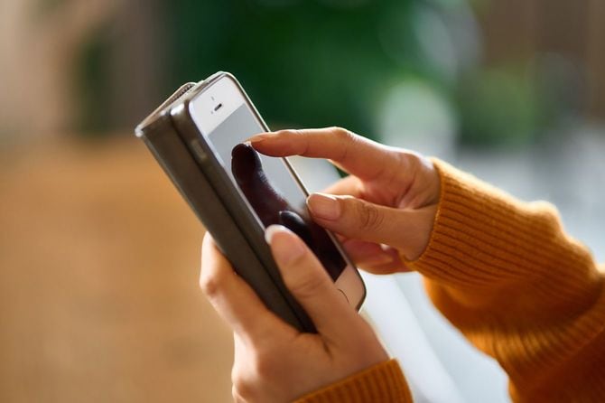 スマートフォンでSNSに投稿する女性の手元