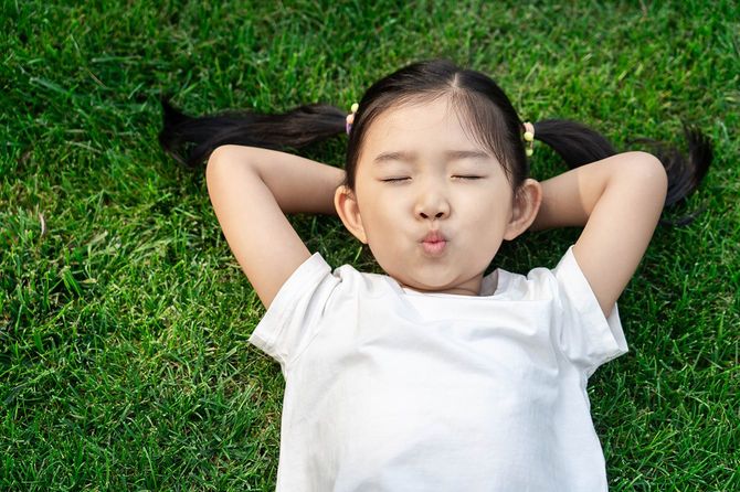 芝生の上に横たわっているかわいい女の子