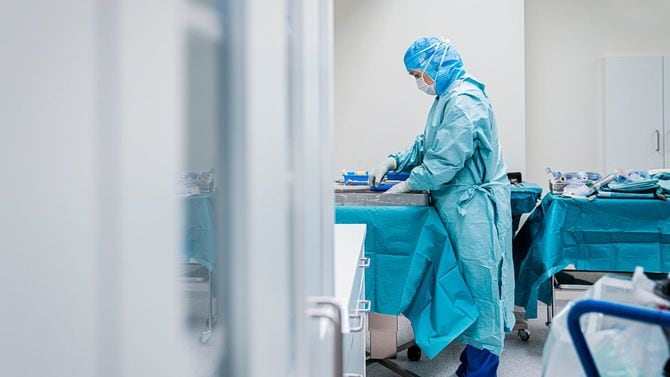 手術の準備をしている女性医師。彼女は感染防具を着用している。