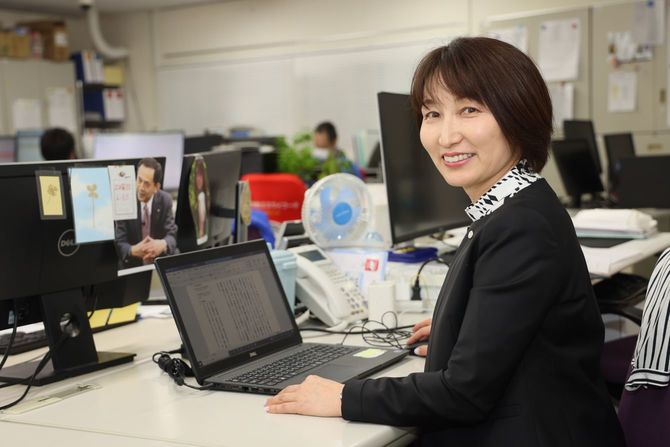 エスワイフード社内、久美さんの自席にて。目の前には重雄さんの写真が飾られている