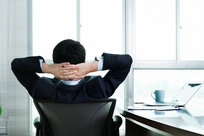 オフィスの椅子にもたれかかるビジネスマン