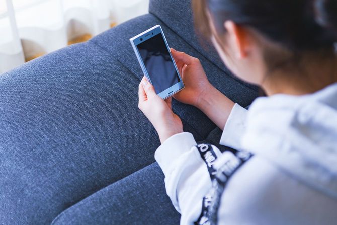 スマホでゲームをする女の子