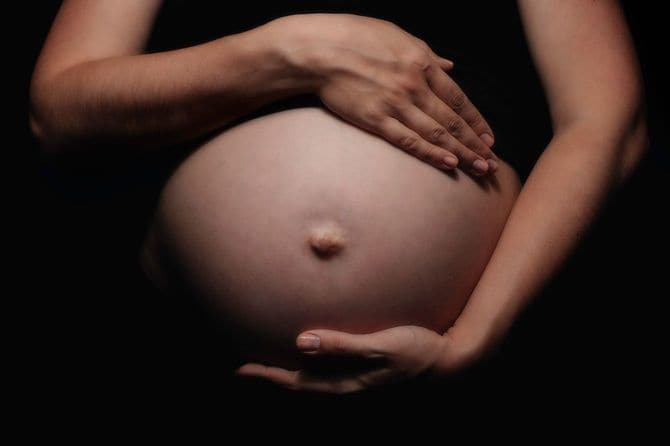 胎児を抱きしめる妊婦