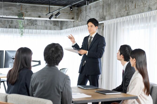 オフィスで新入社員を教育するビジネスマン