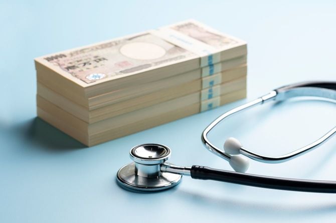 100万円束5つが積まれた手前に聴診器