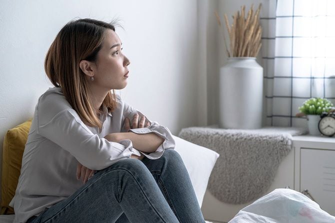 部屋で物思いにふける女性