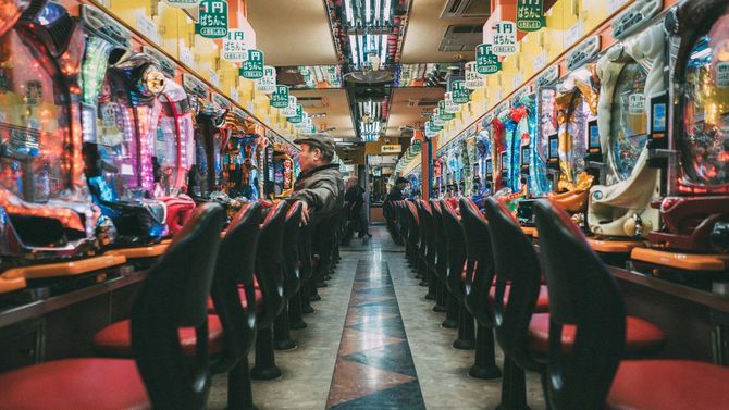 大阪・新世界のパチンコ店で一人、パチンコ台に着く男性