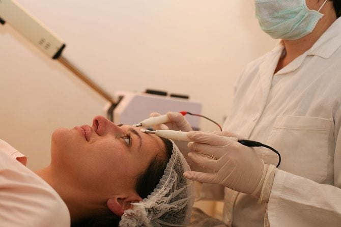 美容院でフェイスリフトを持つ若い女性