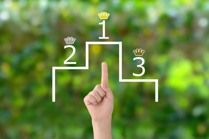 宙に浮いた表彰台のイラストの1位を指さす手