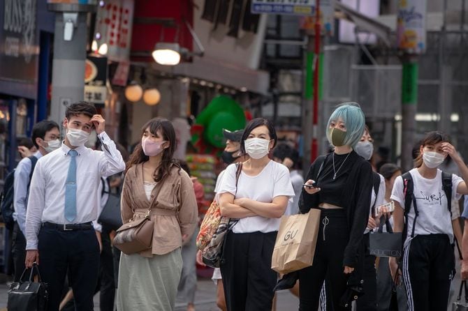 渋谷交差点を歩くフェイスマスクを持つ人々の群衆