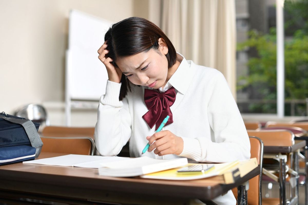 問題を解けずに頭を抱えている女子学生