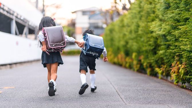 手をつないで走る日本の小学生