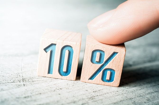 テーブルの上に女性の指で配置される10％と書かれた木製のブロック