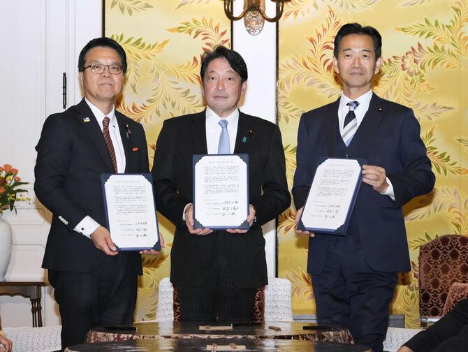 「103万円の壁」の引き上げなどで合意し、文書を持つ(左から)国民民主党浜口、自民党小野寺、公明党岡本の各政調会長=2024年11月20日午後、国会