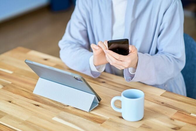タブレットPCとスマートフォンを操作する女性