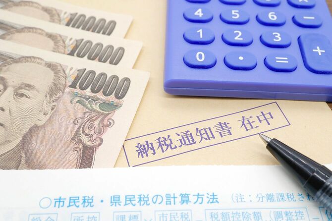 住民税の納税通知書と電卓と一万円札3枚