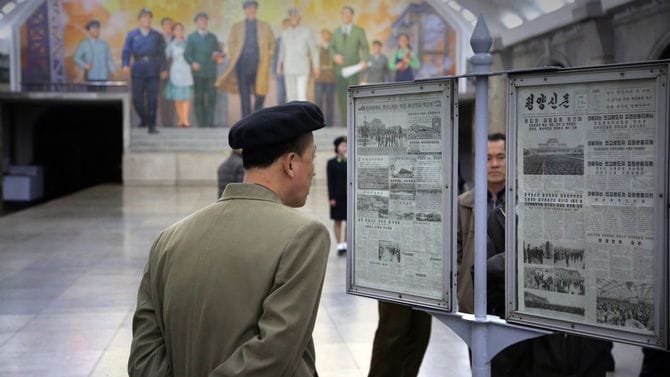 平壌の地下鉄で新聞を読んでいる人