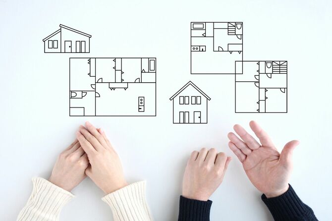 見取り図を見ながら新居のレイアウトについて話し合うカップルのイメージ