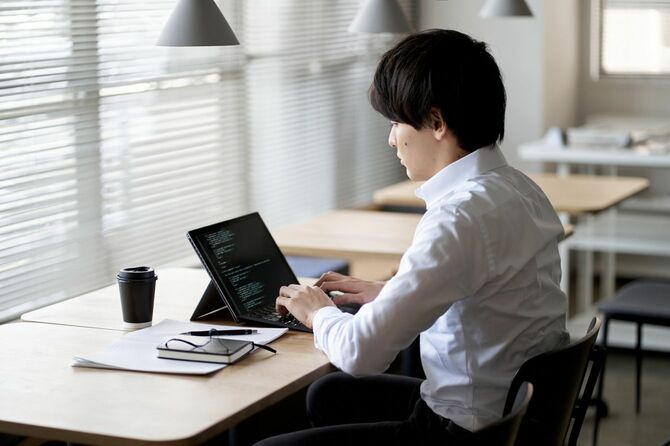 ノートパソコンでコードを書くプログラマー