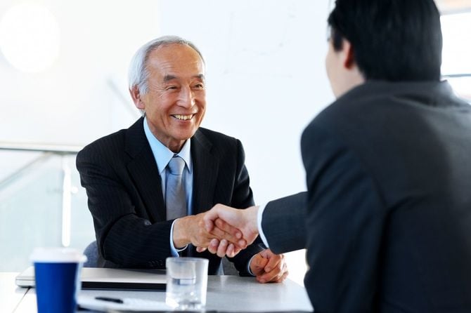 会議中に握手を交わすビジネスマン