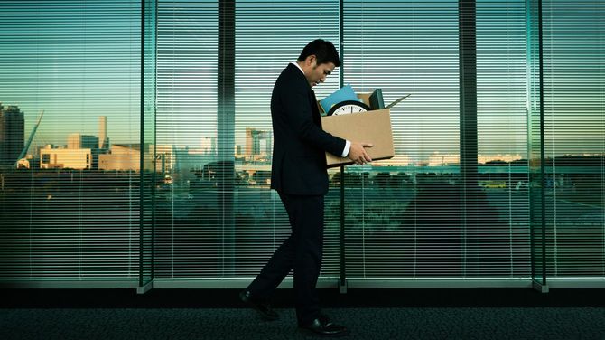 解雇や経済不況の中で、自分の持ち物を持って仕事を辞める日本のサラリーマン