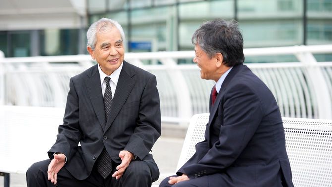 アジアのシニア男性らがビジネスに関して話し合っている