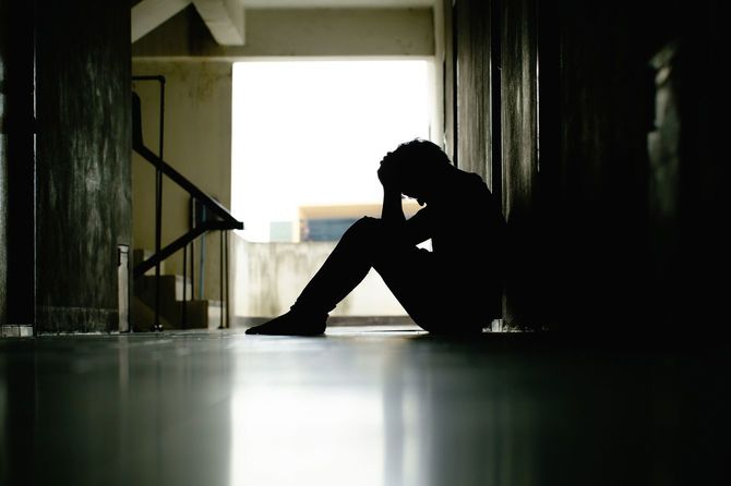 頭を抱えて座っている落ち込んだ男