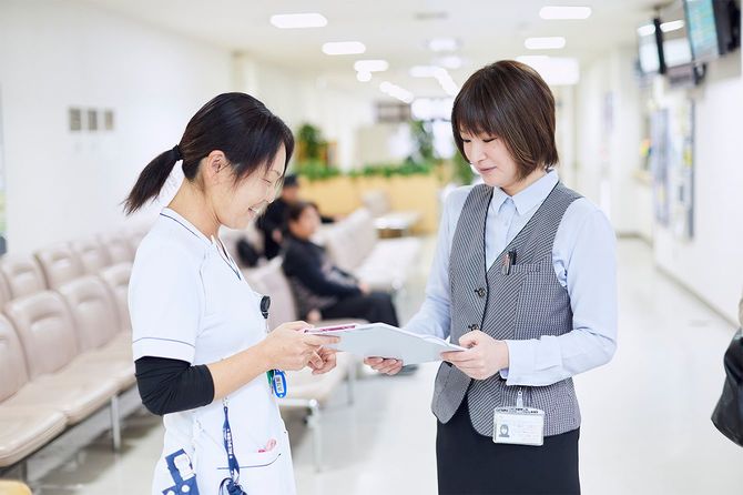 (写真右)鳥取大学医学部附属病院で外来クラークを担当する鷲見万里子さん